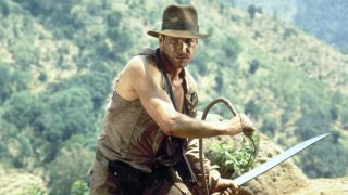 Harrison Ford's Indiana Jones holding whip and machete in Temple of Doom
