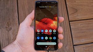 Nokia 7.2 i en hånd over et tregulv