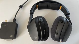 The Glorious GHS Wireless InfinitePlay gaming headset in black and orange on a plain white desktop.