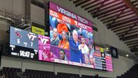 The new Daktronics LED scoreboard at Virginia Tech displaying stats and the head coach pointing to a player. 
