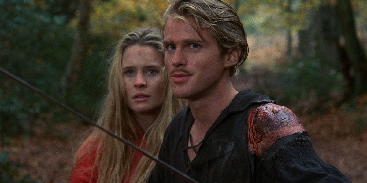 Westley (Cary Elwes) brandishes his sword while standing in front of Buttercup (Robin Wright) in &#039;The Princess Bride&#039;