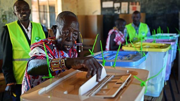 An elederly Maasai woman is watched over by an IEBC official as she casts her vote in Ilngarooj, Kajiado County, Maasailand, on March 4, 2013 during the nationwide elections. Long lines of Ke