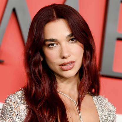 dua lipa wears a silver dress on the red carpet