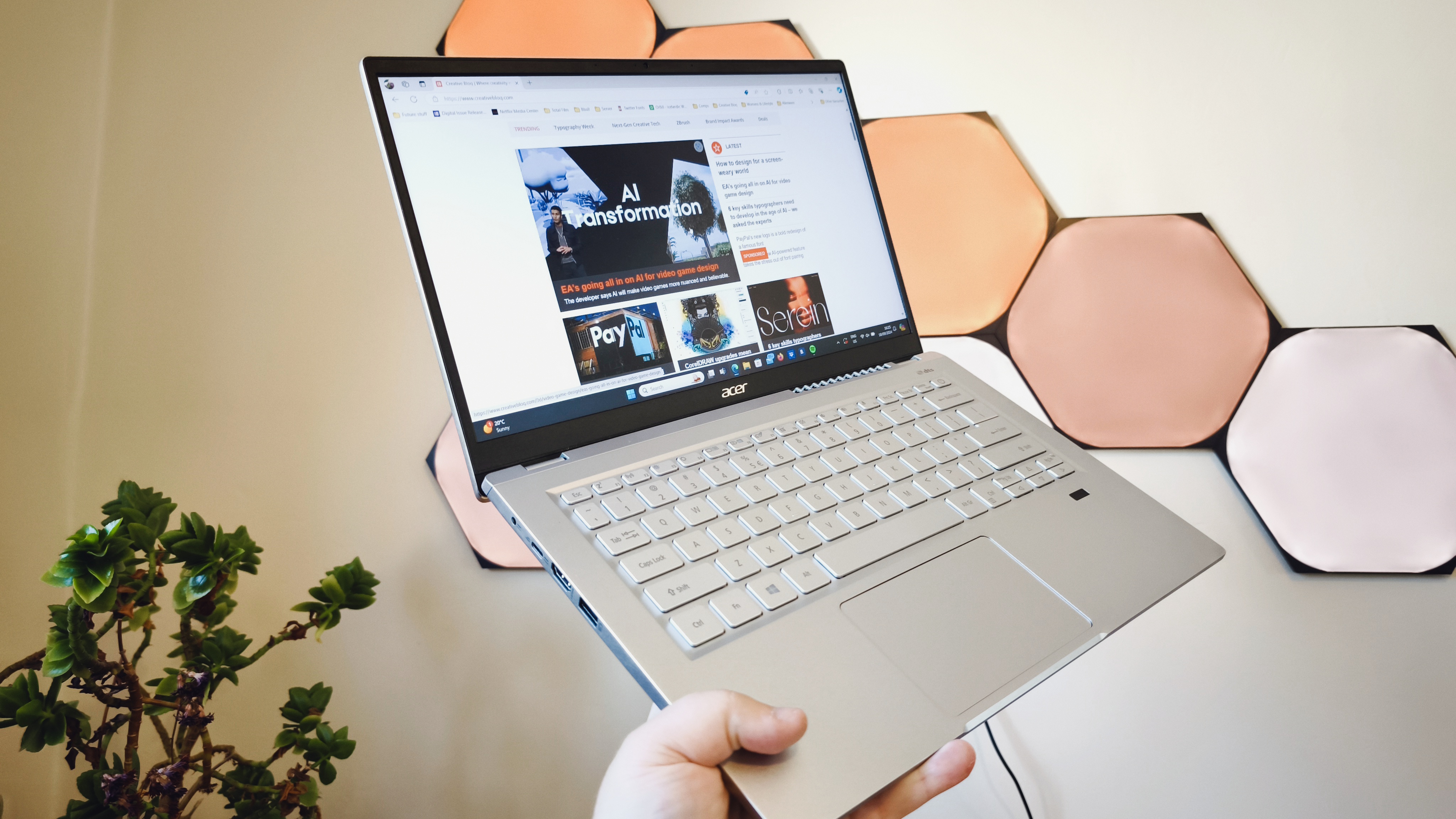 A silver Acer Swift 3 laptop on a light wooden desk