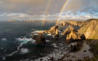 Rainbows slant out of the rocky shores of the Isle of Lewis in Scotland. Photographer Richard Fox Writes: "My wife and I visited the Isle of Harris and Lewis on holiday for a week. One evening, after a day out on Lewis, we stopped off at Mangersta sea stacks one evening. It was pretty windy on the cliff tops, making long exposures quite challenging. All of a sudden a few rain showers passed over as the late evening light broke though, providing an amazing set of rainbows!"