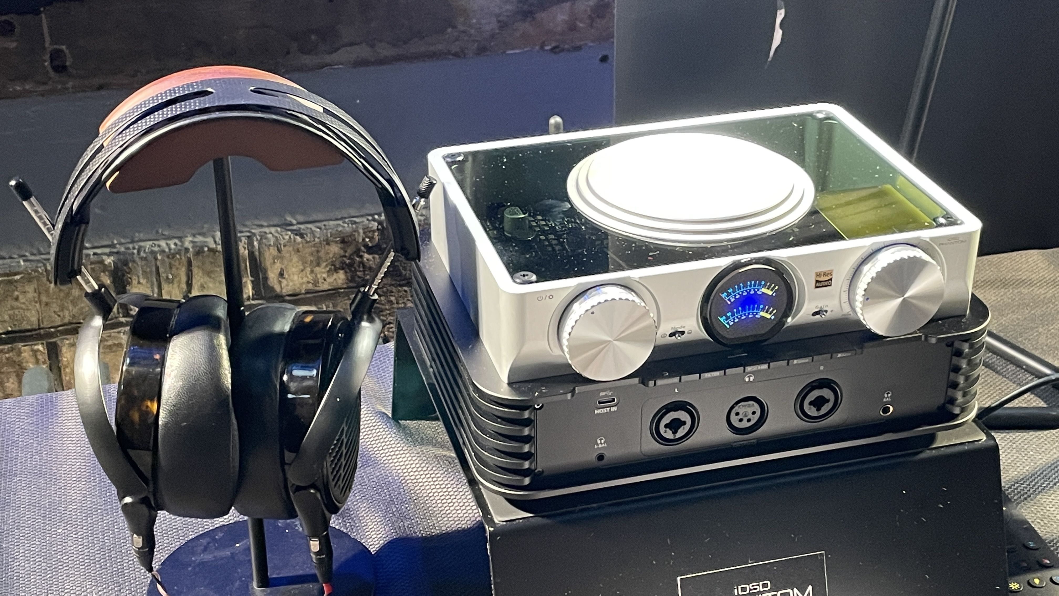 The formidable iFi iDSD Phantom in Tower Bridge, London, used with headphones and illuminating the front panel 