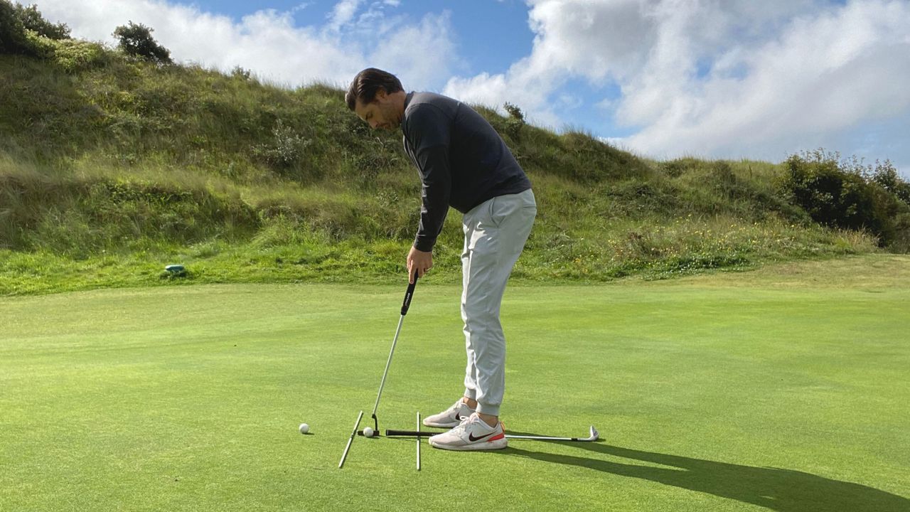 Joe Ferguson using alignment sticks for putting practice