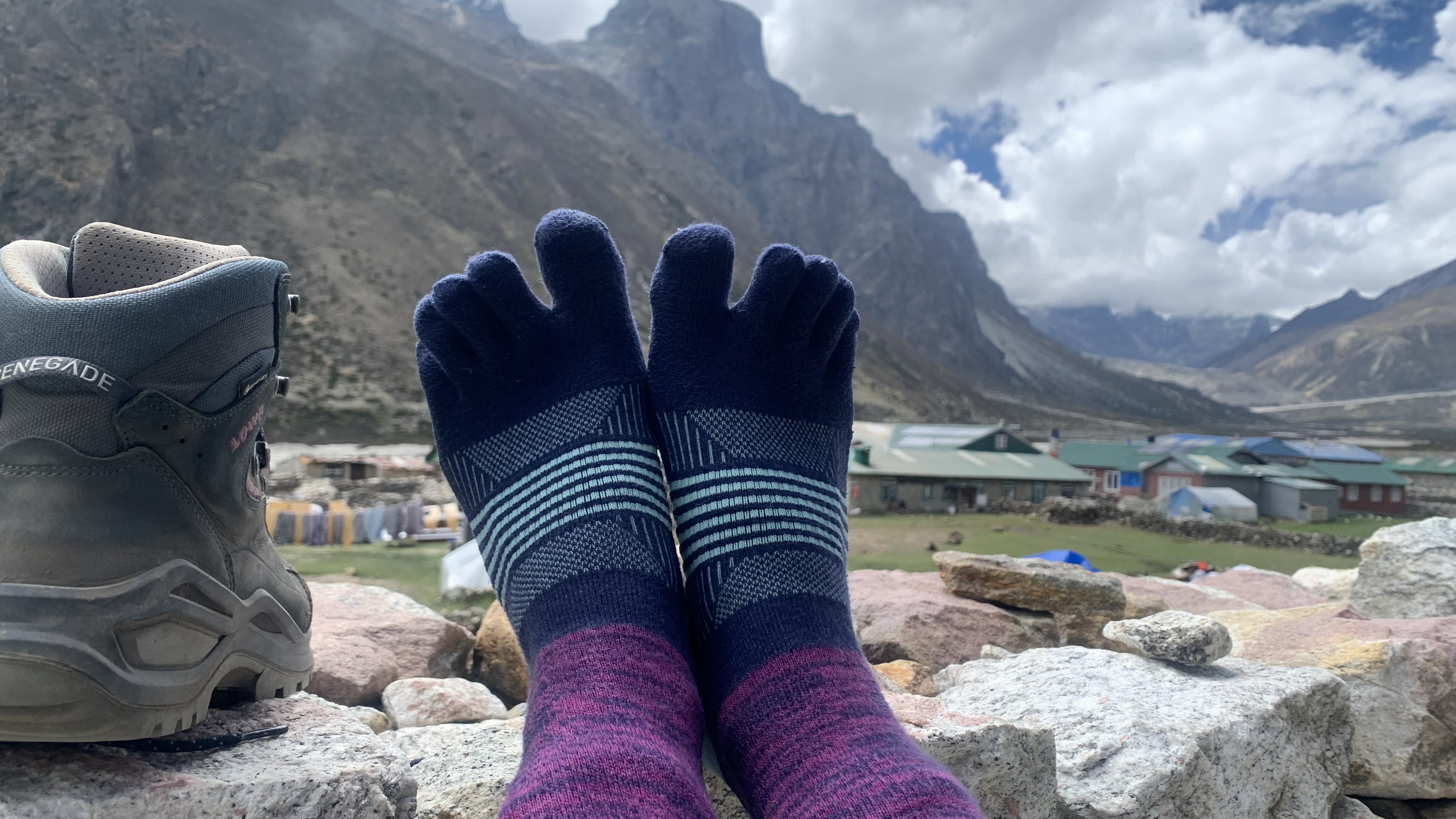 Feet wearing the Injinji Trail Midweight Crew toe socks with Himalayan mountains in the background