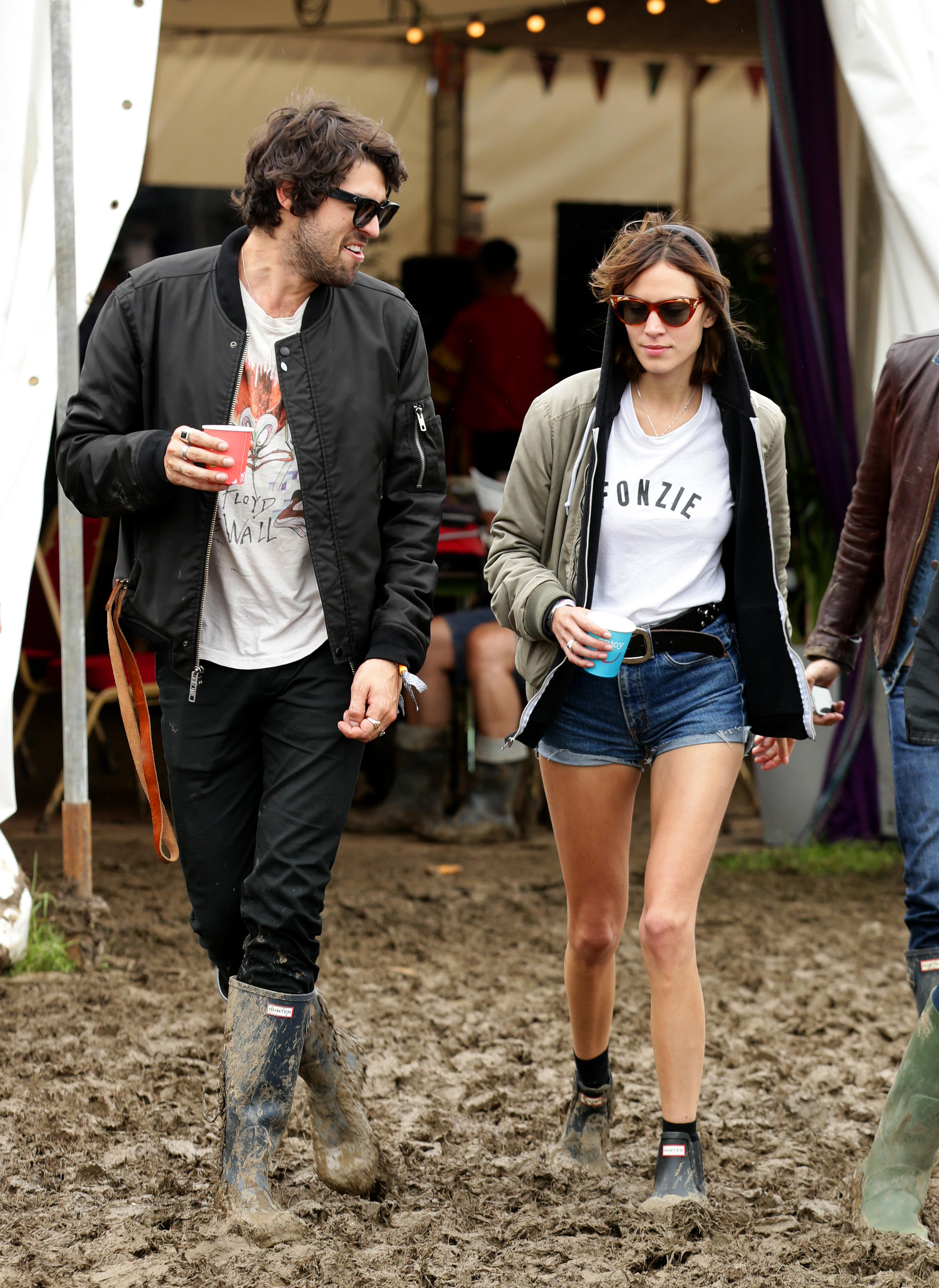 Alexa Ching wearing Hunter welly boots and walking through the mud at Glastonbury
