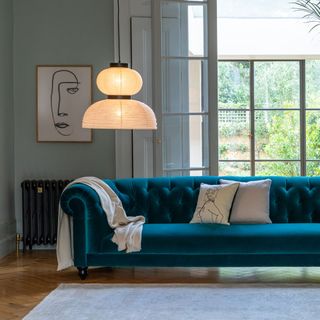 living area with blue sofa and hanging light