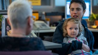 Margaret Qualley as Alex, holding her daughter on her lap in Maid
