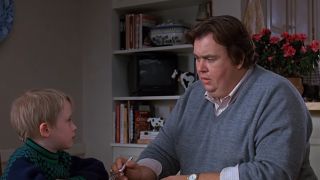 Macaulay Culkin and John Candy talking at a table in Uncle Buck