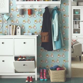 A hallway with a bicycle-print wallpaper and an IKEA HEMNES shoe cabinet in white