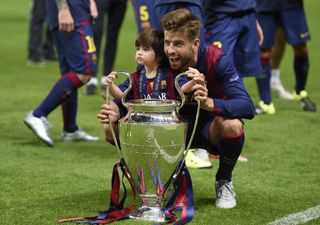 Gerard Pique celebrates with the Champions League trophy alongside son Milan after Barcelona's win over Juventus in the 2015 final in Berlin.