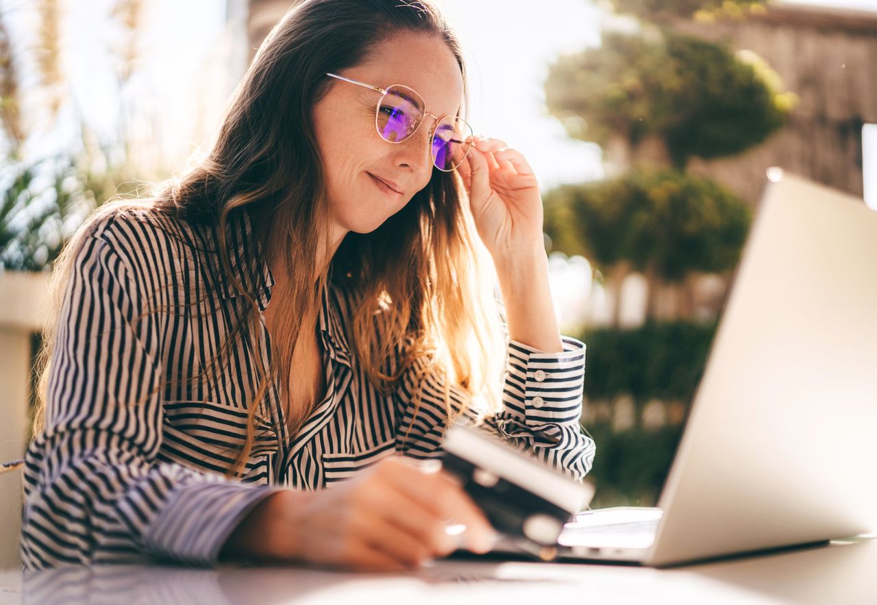 Businesswoman is working on the laptop, making online purchases with a card