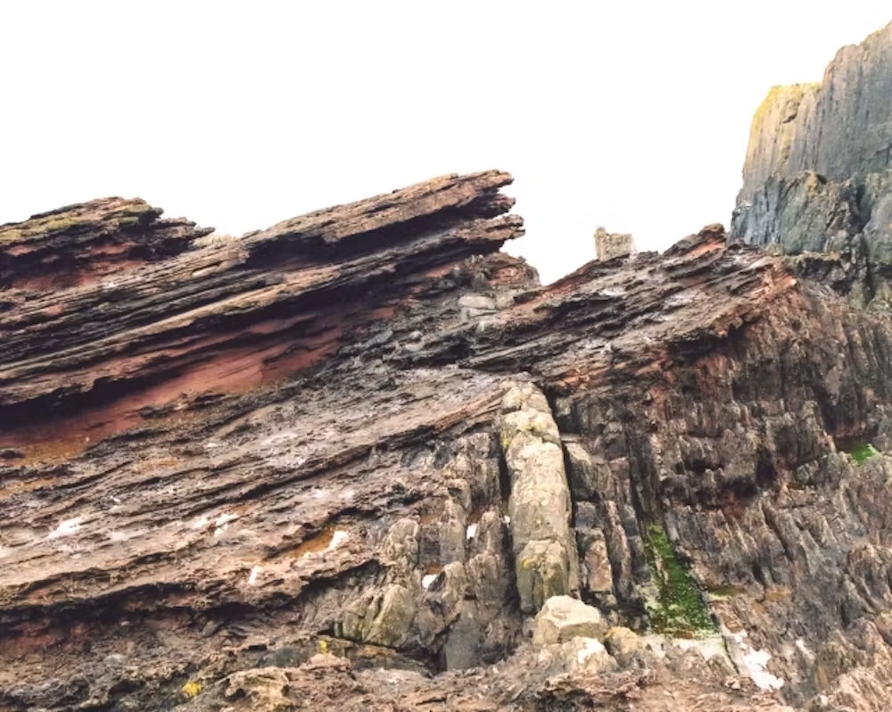 an image of a rock formation with vertical layering on the bottom and horizontal layering on the top