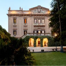 exterior of grand Italian villa with balconies and surrounding trees