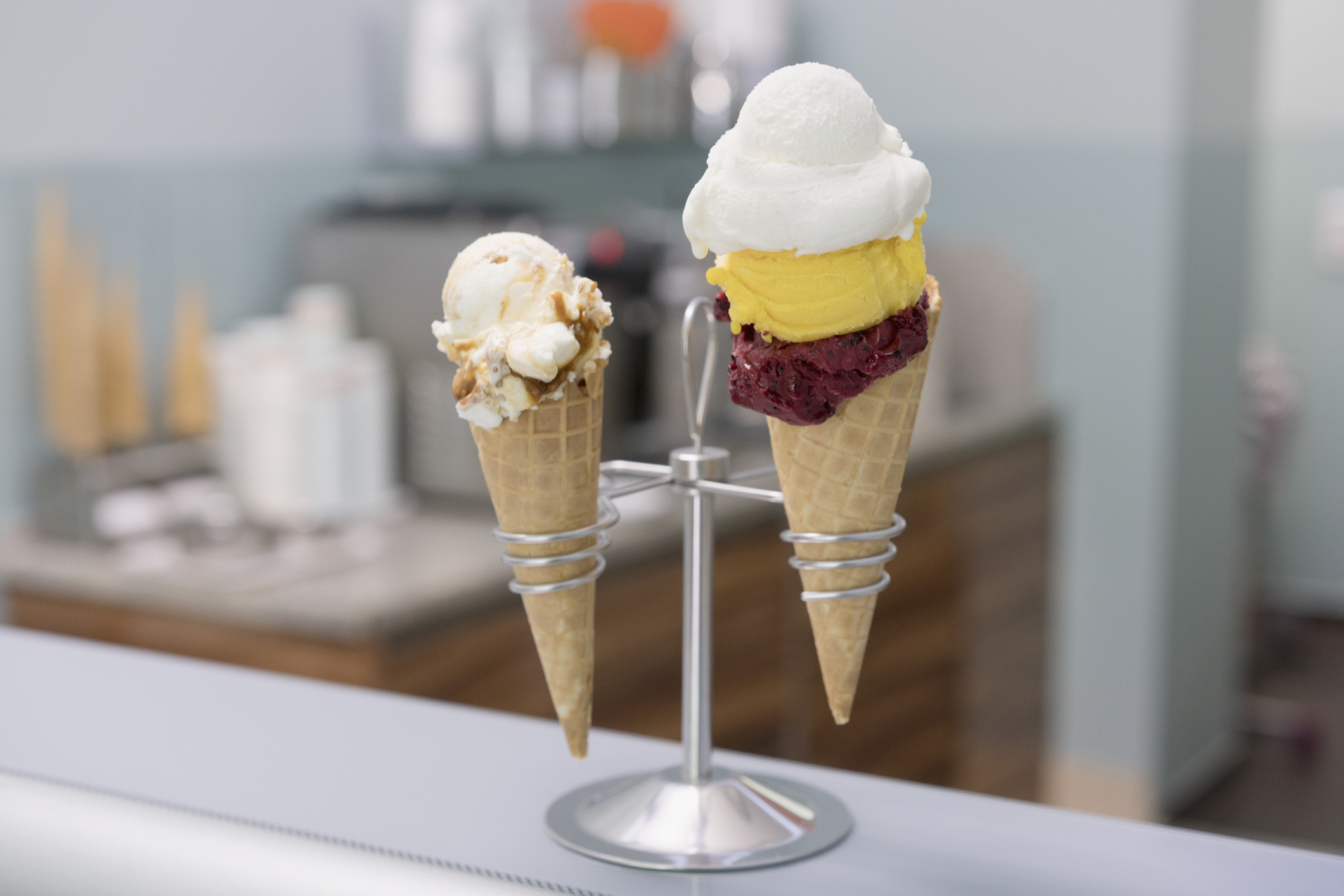 Various ice cream cones in holder on counter at store - stock photo