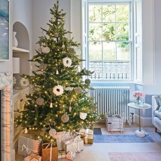 Christmas tree in corner of a room with neutral decorations