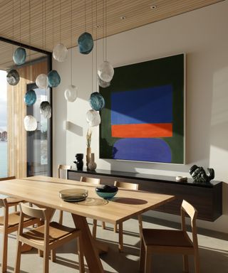 oversized artwork and pendant lighting in neutral dining room
