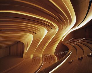 An auditorium style room with steps, seating and walls with curved details created from strips of American oak