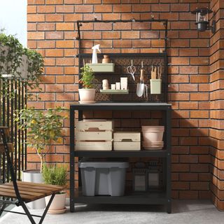 An outdoor kitchen unit against a brick wall