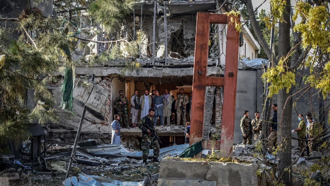 Afghan security personnel inspect the site near a car bomb explosion