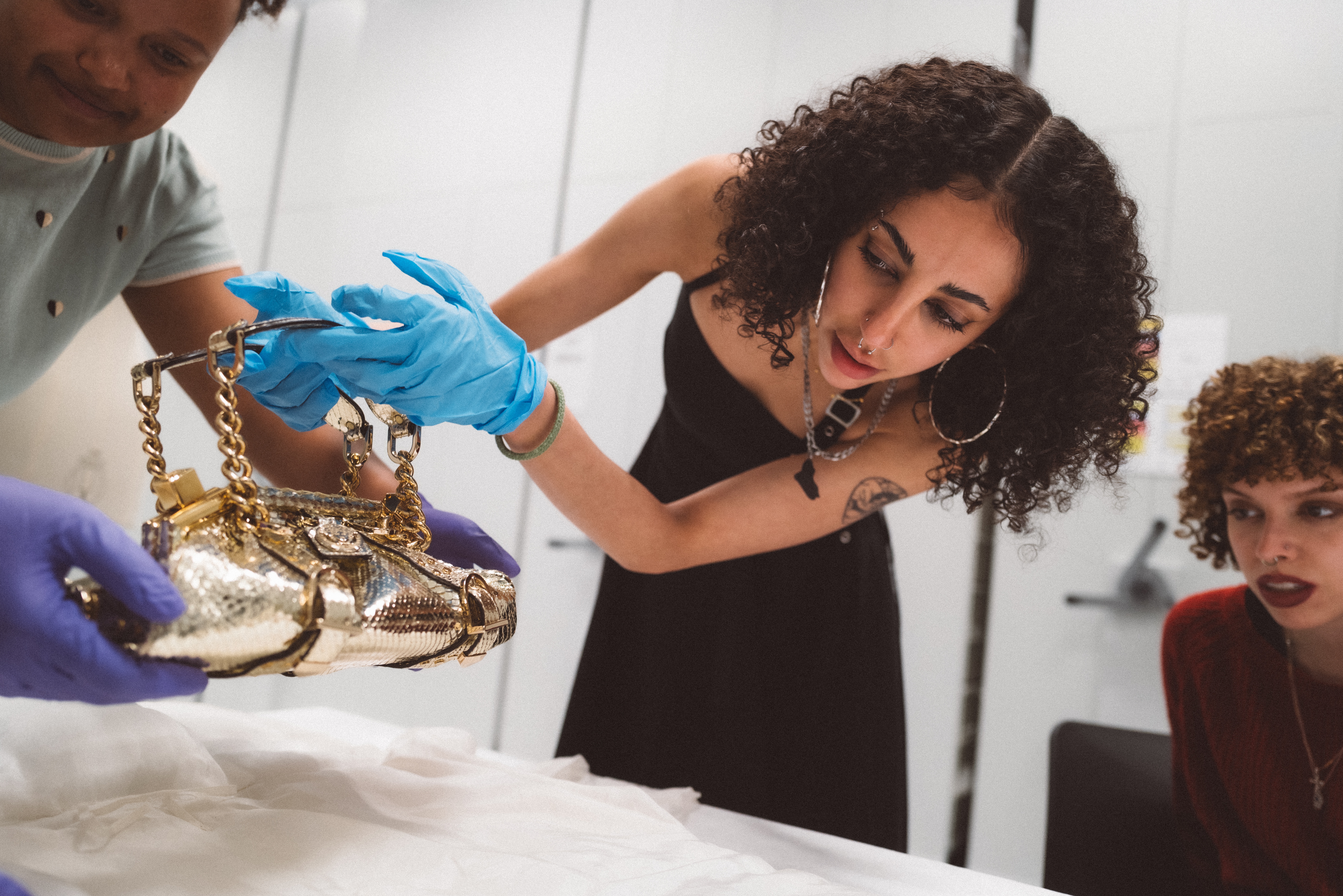 A group of young people observes a series of colorful, sculptural artifacts up close in a museum's specialized unit.