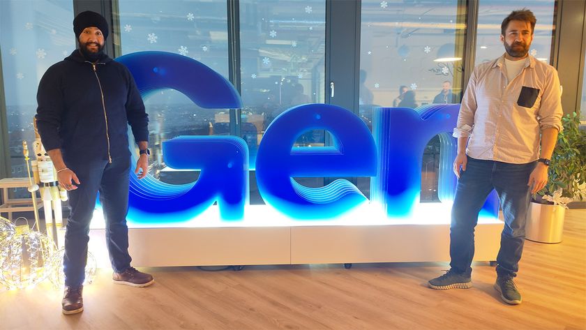 Norton VPN's Product Lead, Himmat Bains and Gen Digital's Head of Privacy Products, Martin Budac stood in front of blue Gen Digital sign in their Prague office 