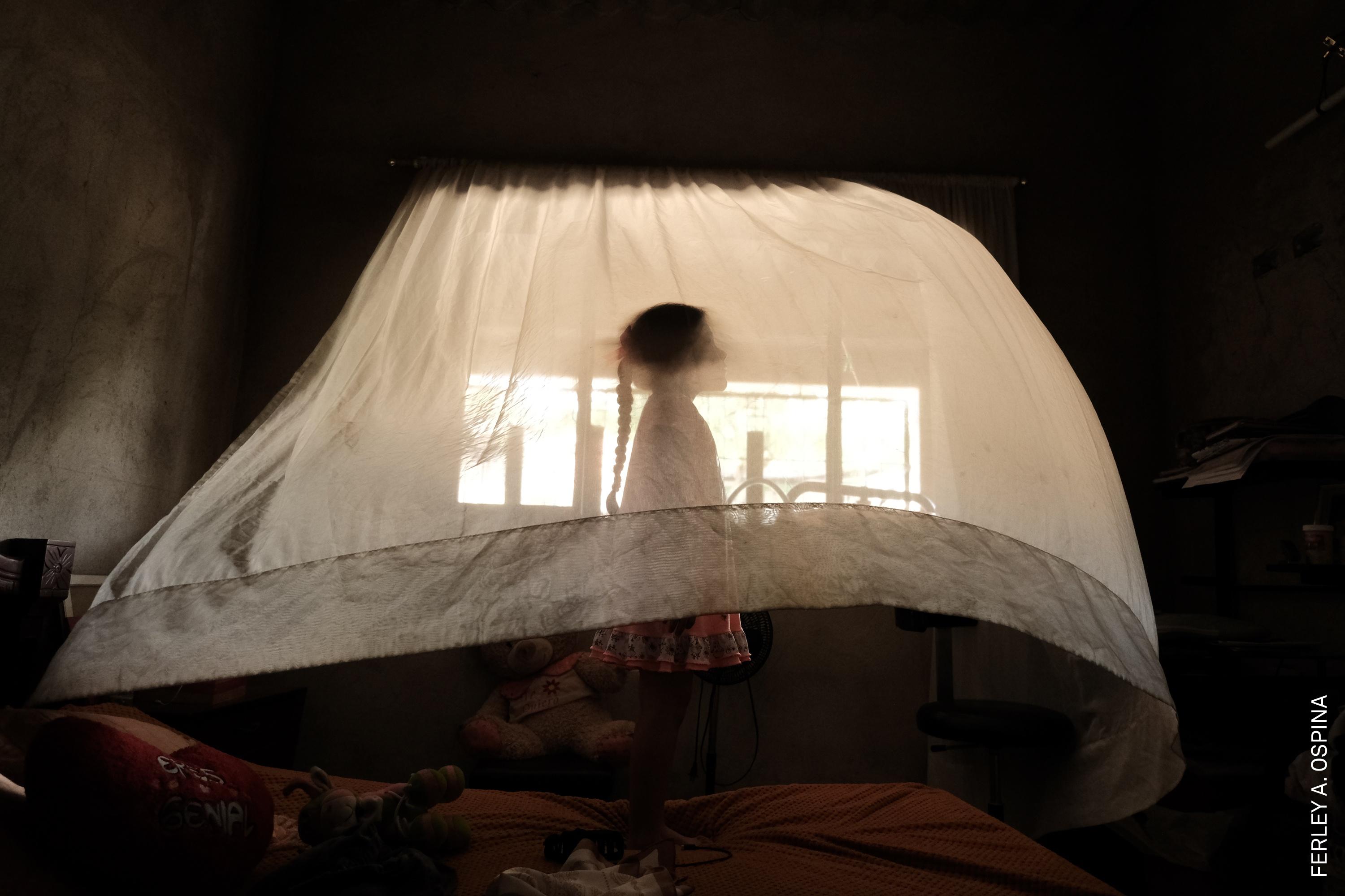 Valeria (5) plays behind a curtain at her aunt&amp;rsquo;s house. She is raised solely by her mother. In her region, 30% of households are headed exclusively by women