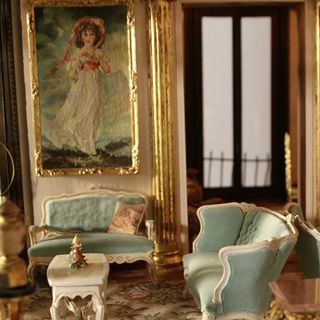 dolls house with blue sofa and wall painting