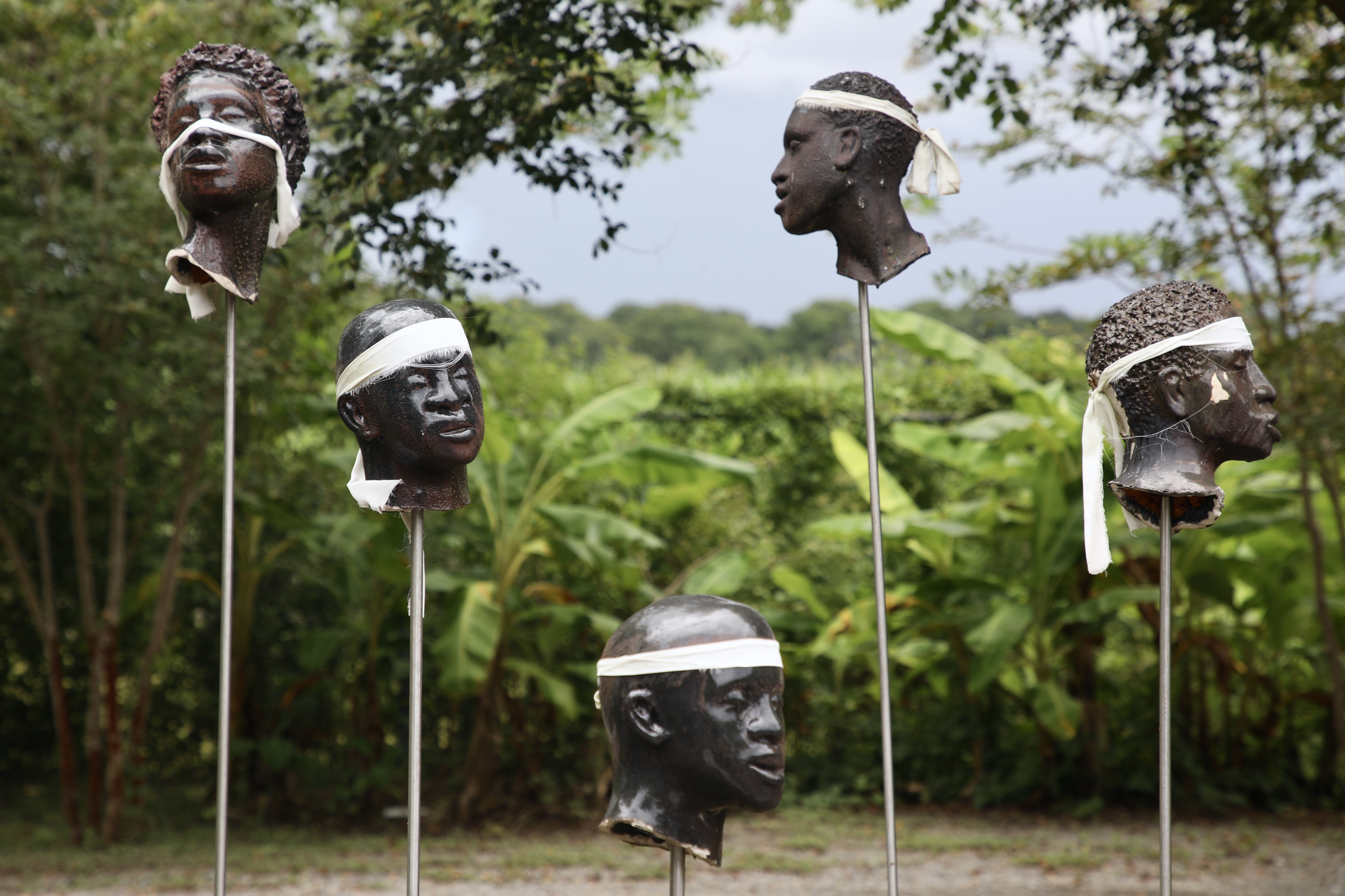 A sculpture by artist Woodrow Nash on display at the Whitney Plantation, depicting severed heads mounted on poles