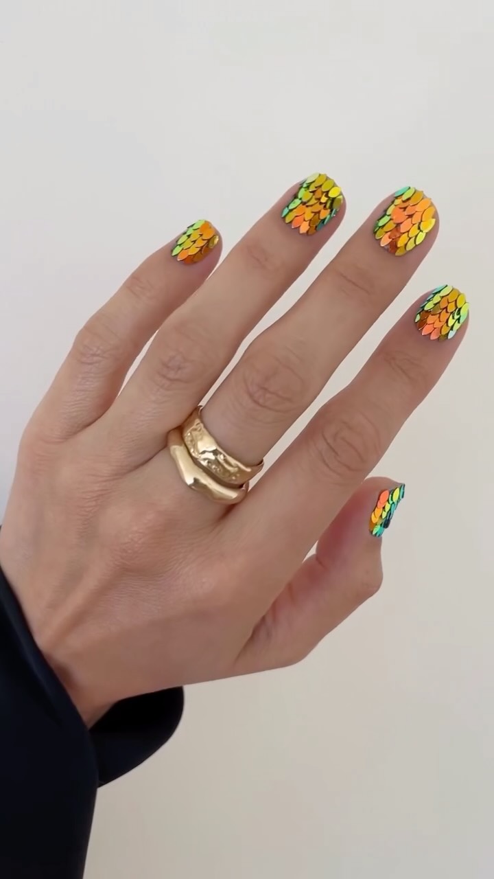 Layered sequin nail art with a holographic effect that resembles dragon scales