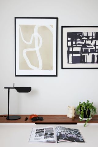 A corner in a living room with artworks