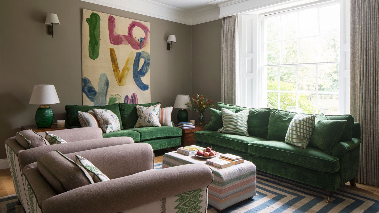 living room with green sofa and pink armchairs, large artwork on the walls, wall lights and table lights