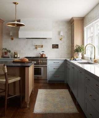 A wooden and blue kitchen with a chrome range cooker and brushed brass hardware