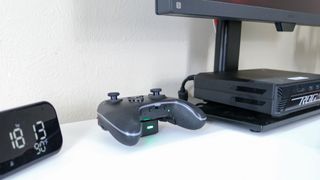 The PowerA OPS v3 Pro controller on its magnetic charging stand on a desk