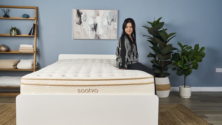 Tom&#039;s Guide Sleep Writer, Eve Davies, sat on the edge of the Saatva Classic mattress - the winner of the Tom&#039;s Guide Best Luxury Mattress award - smiling