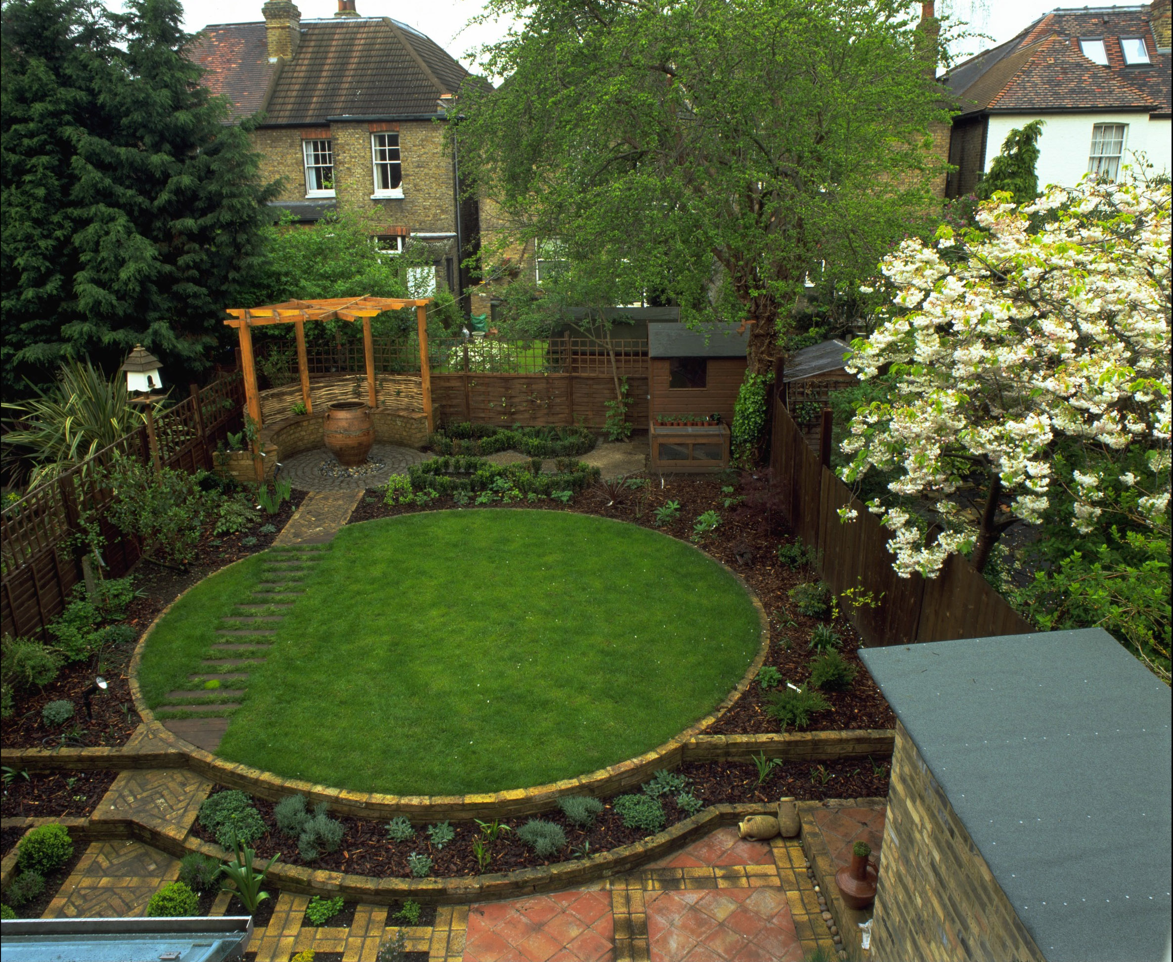 circular lawn with a gazebo & bedding covered with bark mulch