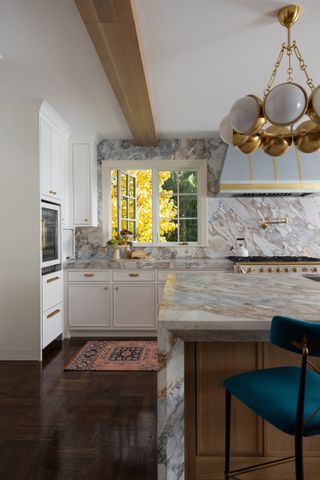 A kitchen with low hung island light and marble island