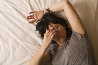 Tired woman on mattress as clocks go back