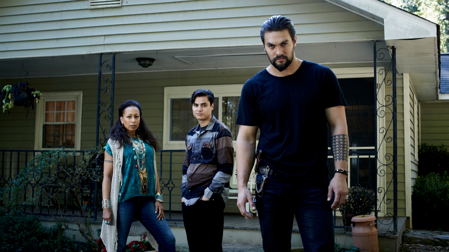 L-R: Tamara Tunie, Kiowa Gordon and Jason Momoa standing in front of a house.
