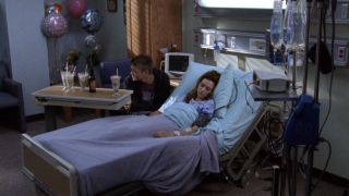 Lucas Scott looks over Peyton Sawyer Scott as she lies in the hospital on One Tree Hill