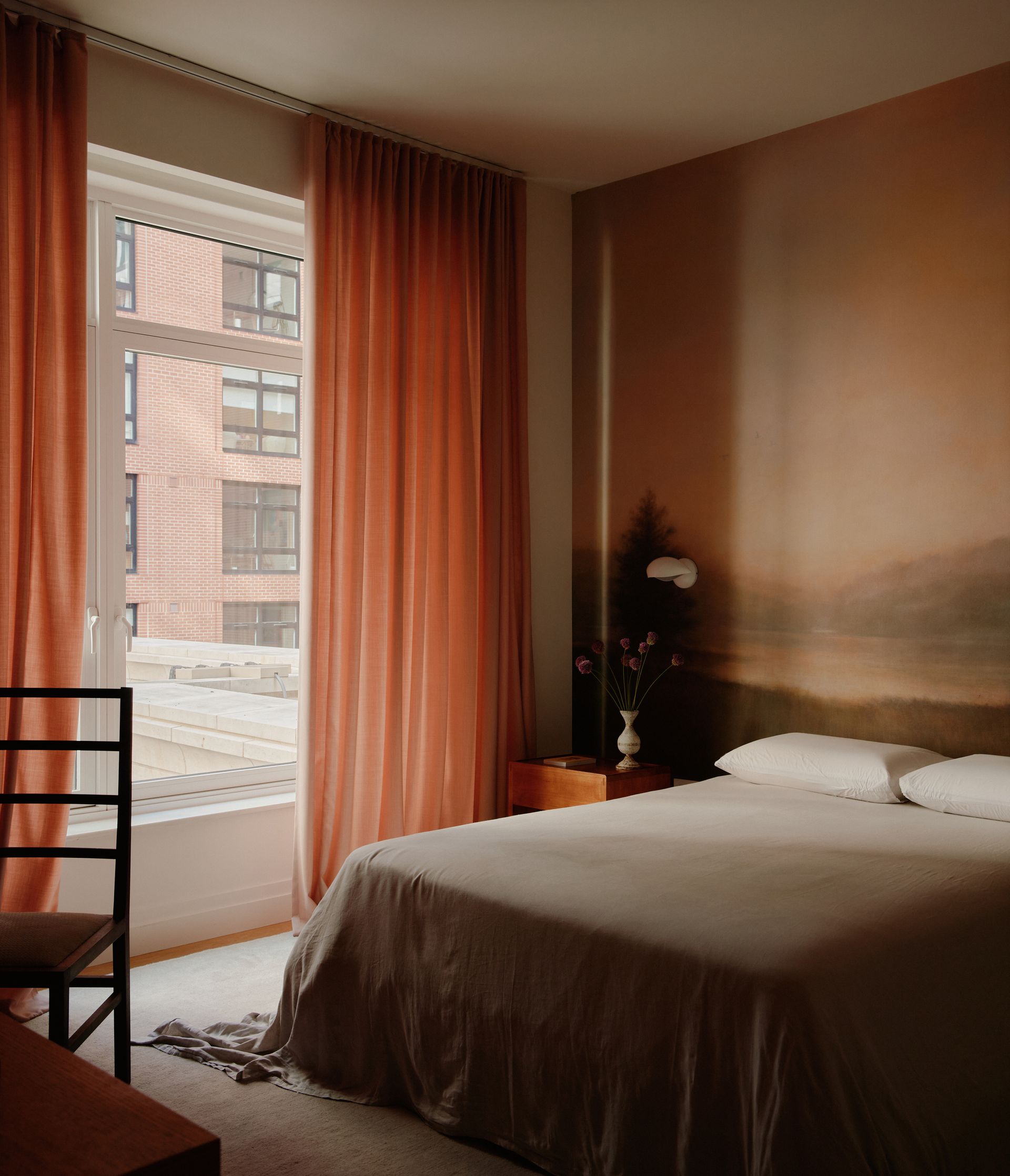A bedroom with neutral colored mural