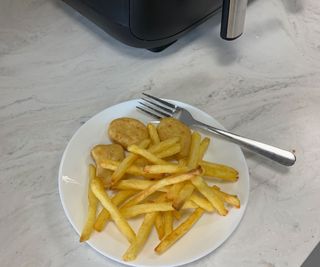 Cooked nuggets and fries on a plate.