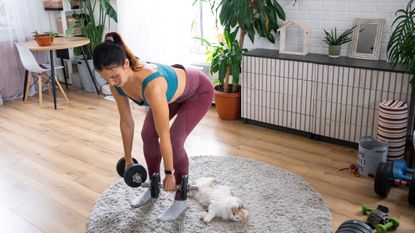 Woman exercising using dumbbells in a domestic setting