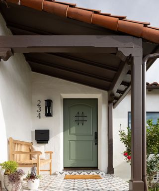 Front porch with bold tiles and green front door