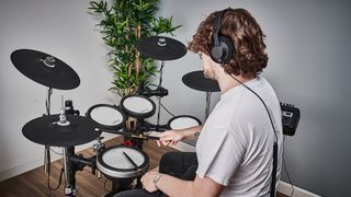 Man plays a Yamaha electronic drum kit in a lounge