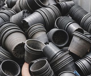 many stacked black plastic pots