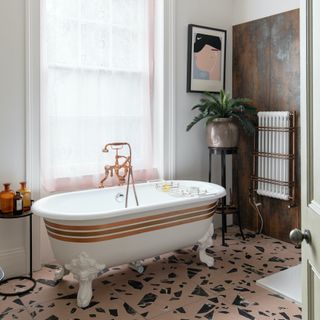 bathroom with terrazzo floor and white striped bath